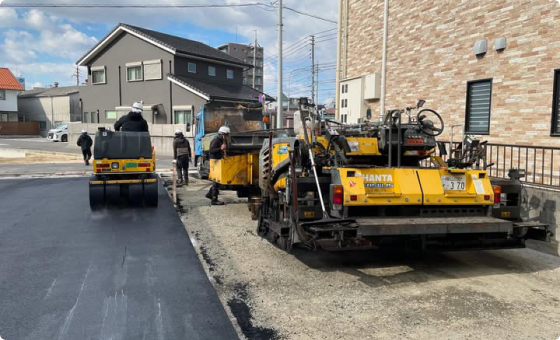 道路の舗装工事を行う重機